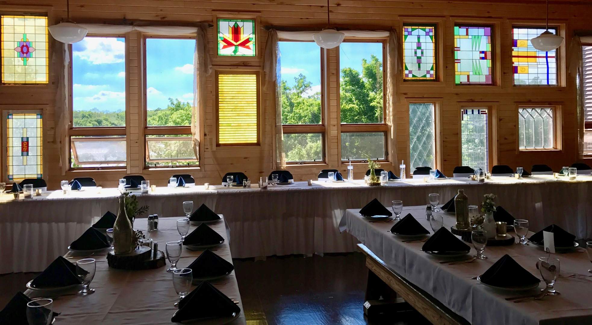 Stained glass windows in dining room of main lodge as backdrop for wedding reception.