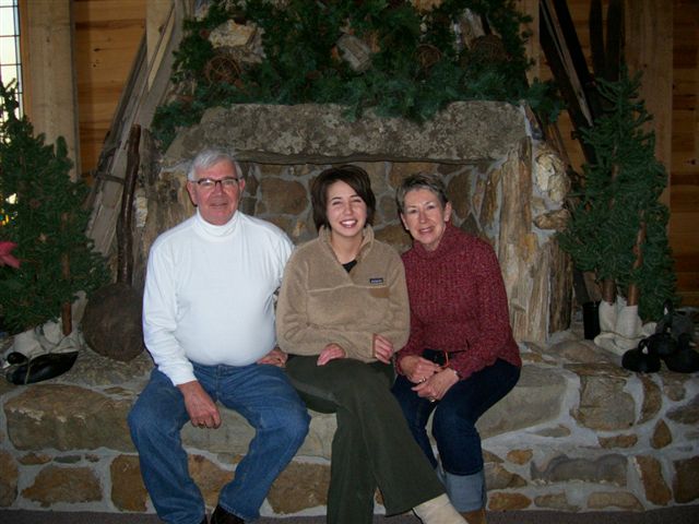Self timer photo of the Bill, Chris and Dana Thomas family in front of the Maplelag fireplace.