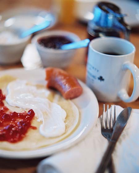 Photo taken by Peter Edwards of the Saturday morning breakfast at Maplelag featuring Norwegian pancakes, lingonberries from Sweden, sour cream, pure maple syrup and farm sausage.