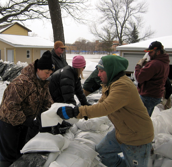 Jonell helping with sand bagging efforts around a Moorhead home as the Red River swells in the background.