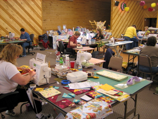 Participants in the Back Porch Quilters retreat working in the large conference room.