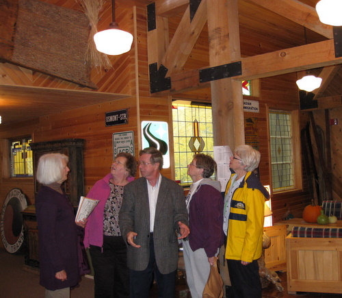 Pastor Lew of Trinity Lutheran Church, Moorhead, providing a first hand account of the mysterious sleds located on the walls at Maplelag, during a Fall color tour today.