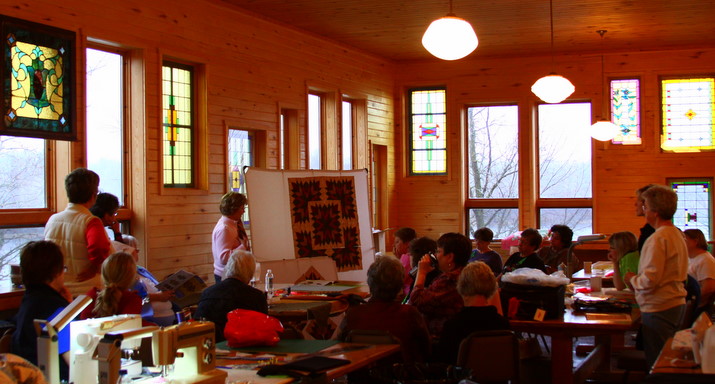 Stained glass windows providing a colorful background for one of the workshops during the Back Porch Quilters Fall retreat.