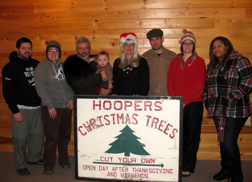 Hooper family holding sign donated to Maplelag from their Christmas tree farm. 